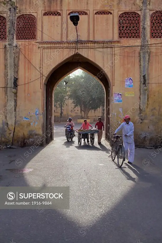 Traffic still flows through a gateway to the City palace as it has done for hundreds of years. Jaipur, Rajasthan, India