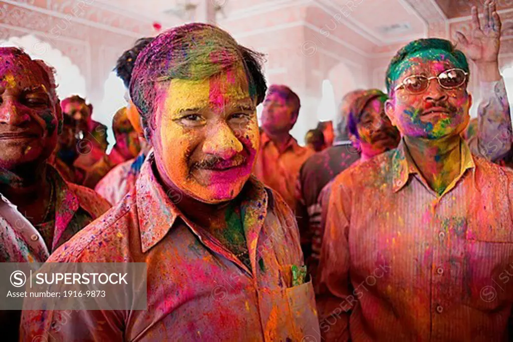 Friends celebrating the Holi spring festival to celebrate the love between Krishna and Radha, in Govind Devji temple,Jaipur, Rajasthan, India