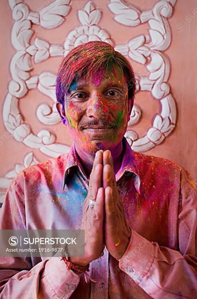 Man celebrating the Holi spring festival to celebrate the love between Krishna and Radha, in Govind Devji temple,Jaipur, Rajasthan, India
