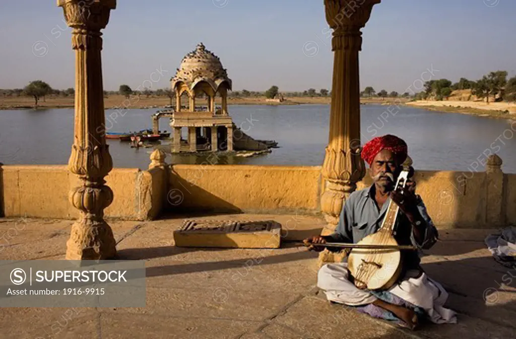 Musician in Gadi Sagar, the tank was once the water supply of the city and is surrounded by small temples and shrines, Jaisalmer,Rajasthan, India