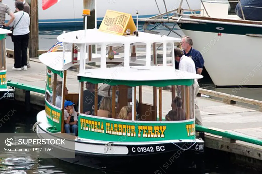 Tiny ferry boats take tourists for tours of Victoria harbor Victoria  Canada