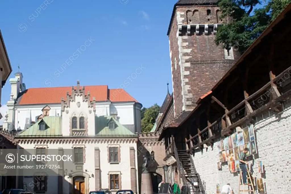 Arists hang works for sale on a small remaining portion of the old city walls Krakow Poland