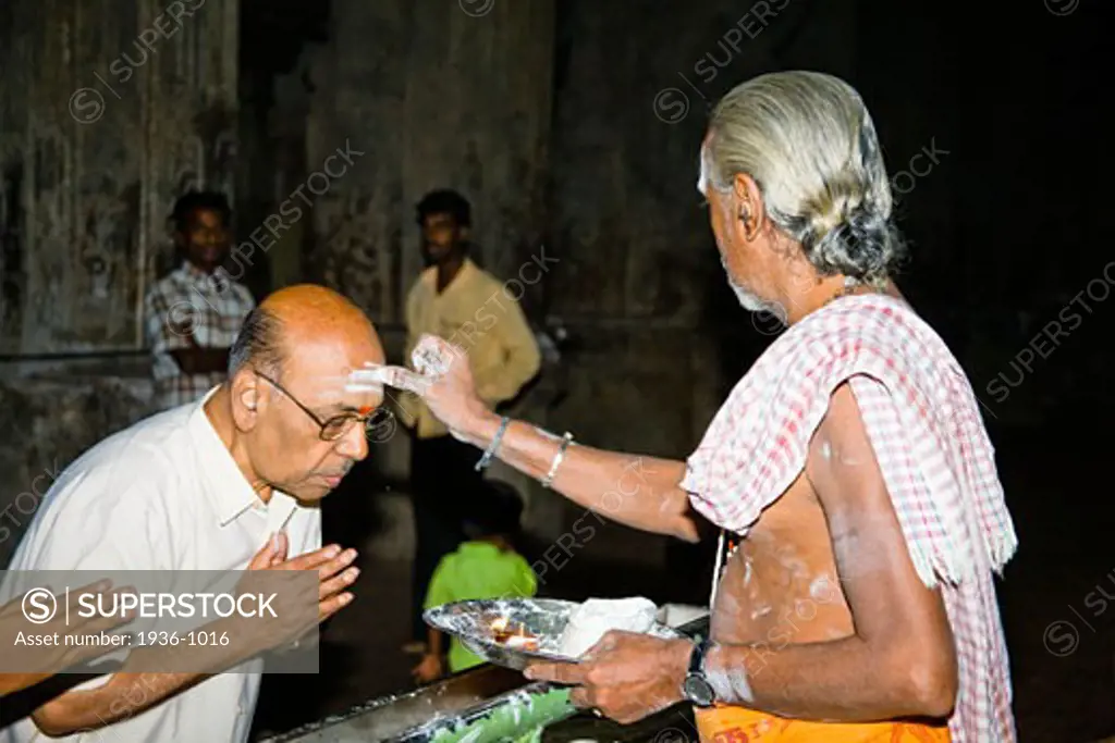 Brahmin applying a tikka to a mans forehead  Meenakshi Temple  Madurai  Tamil Nadu  India