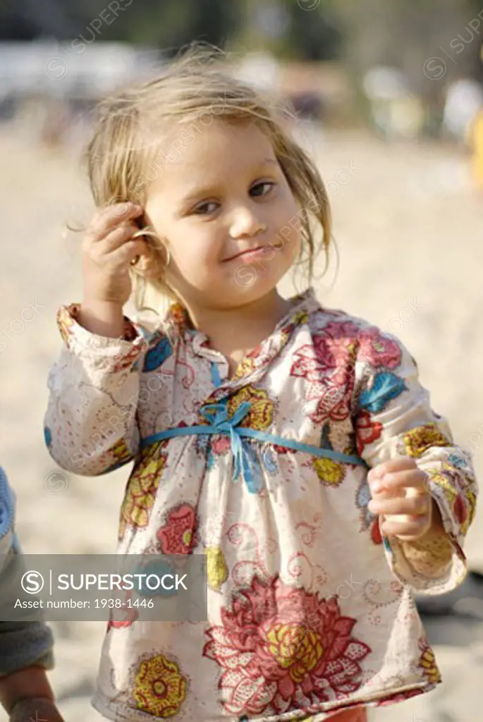 Portrait of a beautiful and tender mixed race small girl  half thai People enjoying sundays in popular Benirras beach  where drum players play until sunset  Ibiza  Spain