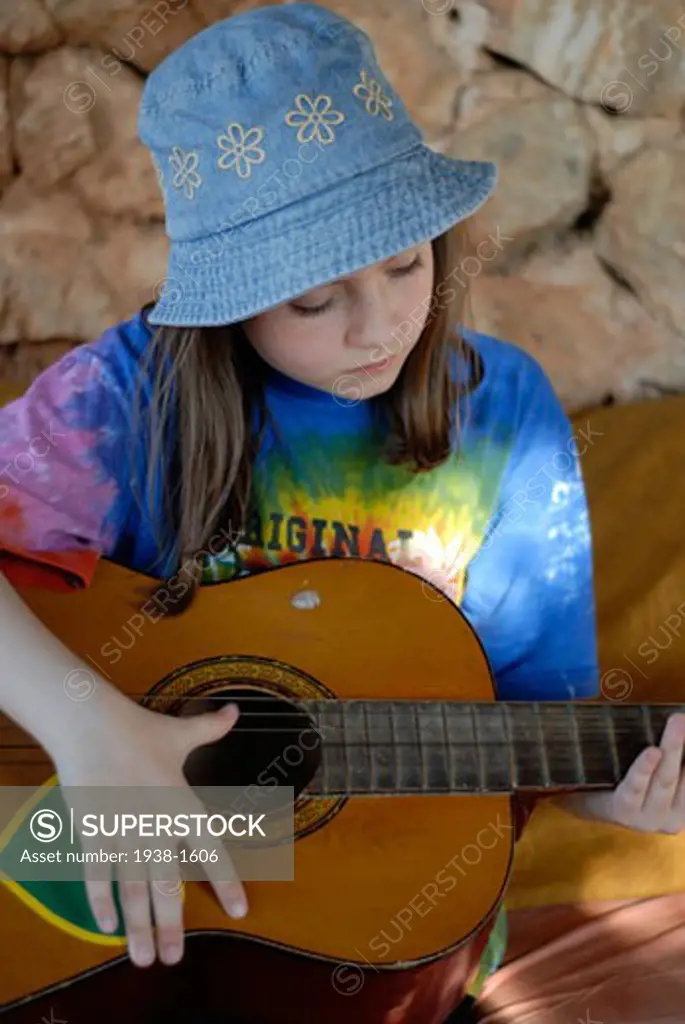 Cute small girl playing the guitar A day at Greenheart s La Casita Verde the little green house is a rapidly evolving model ecological centre visited by around 5000 people each year Ibiza  Spain