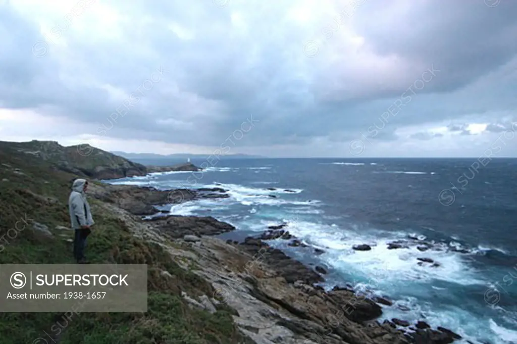 Man watching the sea from the rocks  in Corme  Death Coast  Galicia  Spain