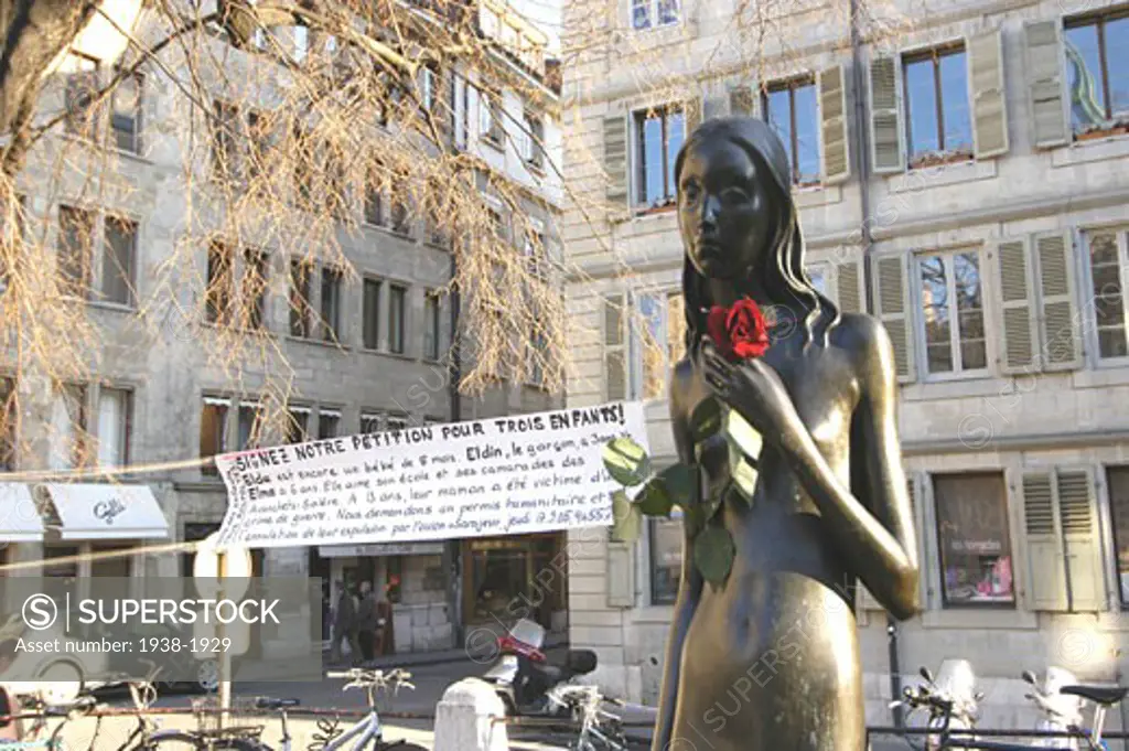 Help petition for three children from Sarajevo  with a banner and a rose placed in the hands of a female sculpture  in Geneva  Switzerland