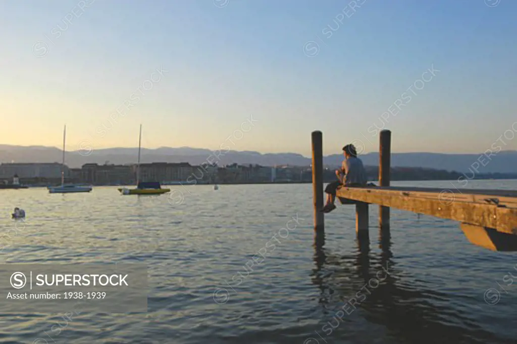 Couple in love sitting on the dock of the lake port  Geneva  Switzerland
