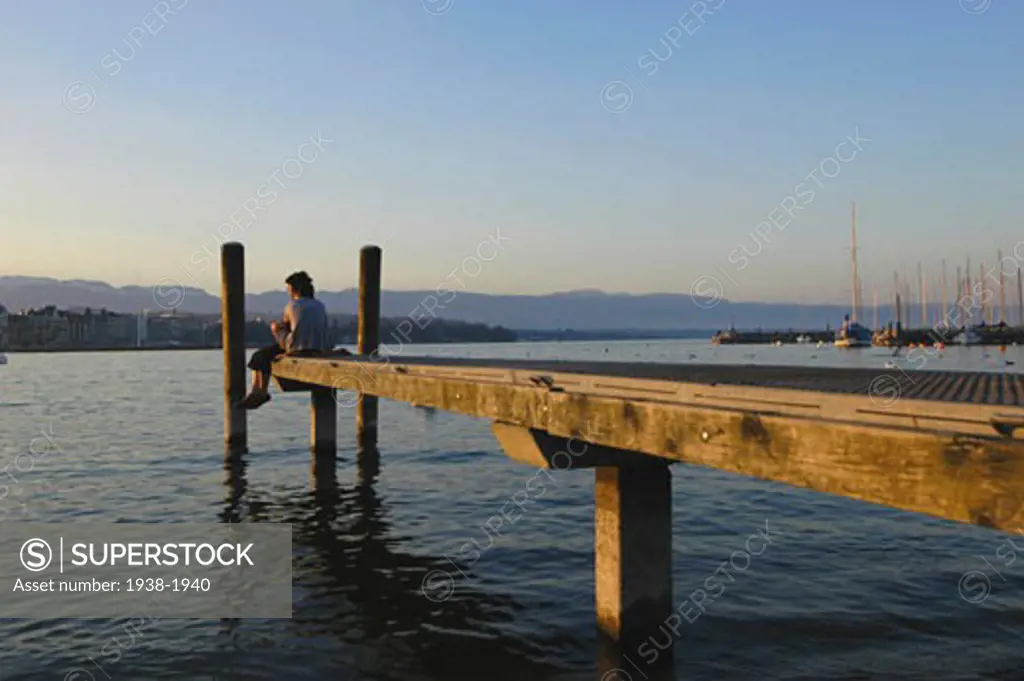 Couple in love sitting on the dock of the lake port  Geneva  Switzerland