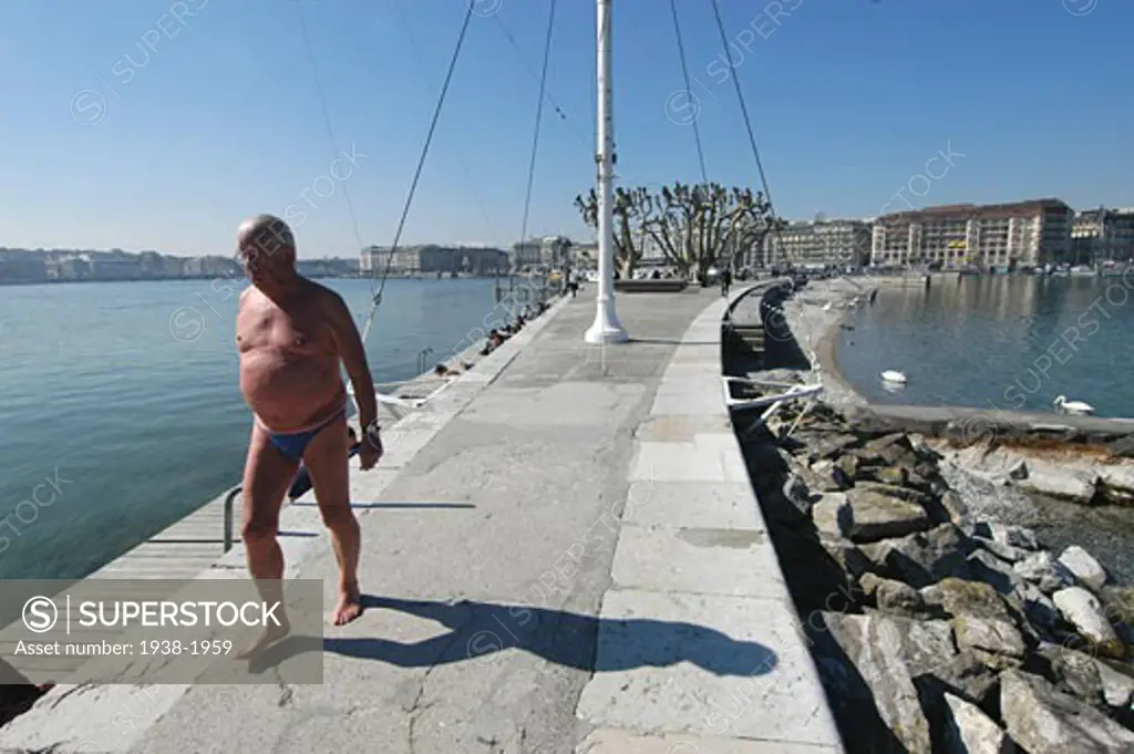 An elderly man going to swim in Bains des Paquis  in Geneva  Switzerland