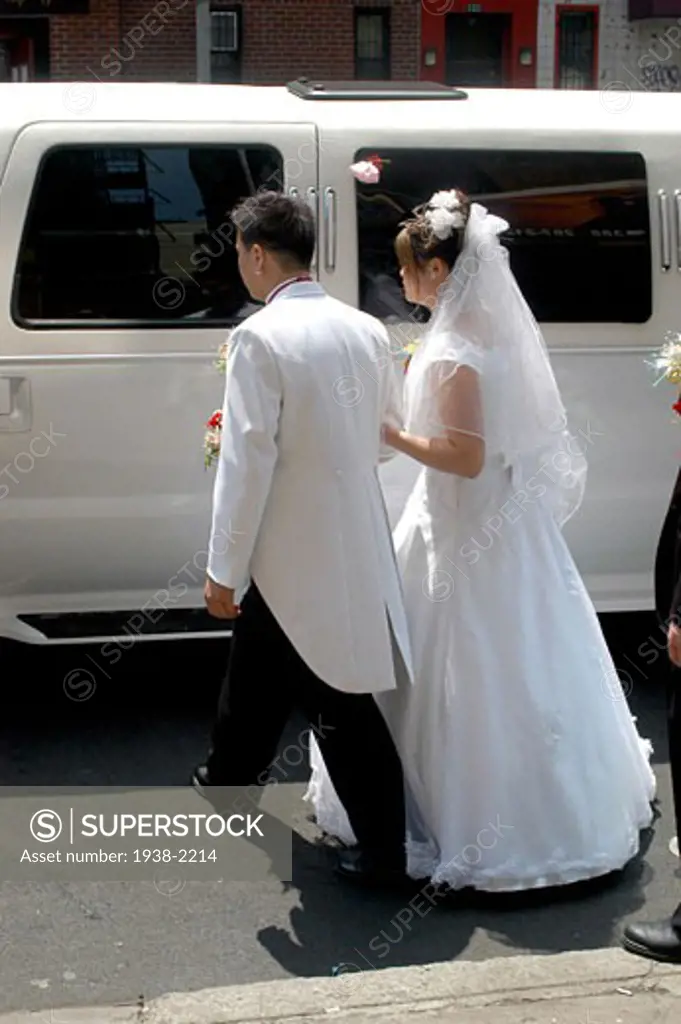 Asian just married couple entering a limousine during the ceremony  in Chinatown  New York