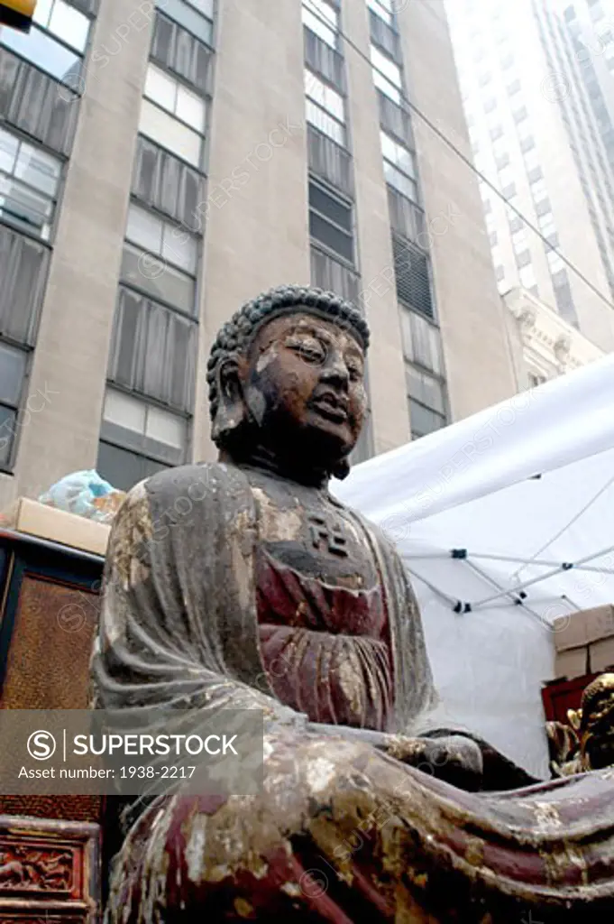 Asian Buddha figure for sale in a street market in 6th Avenue  Manhattan  New York