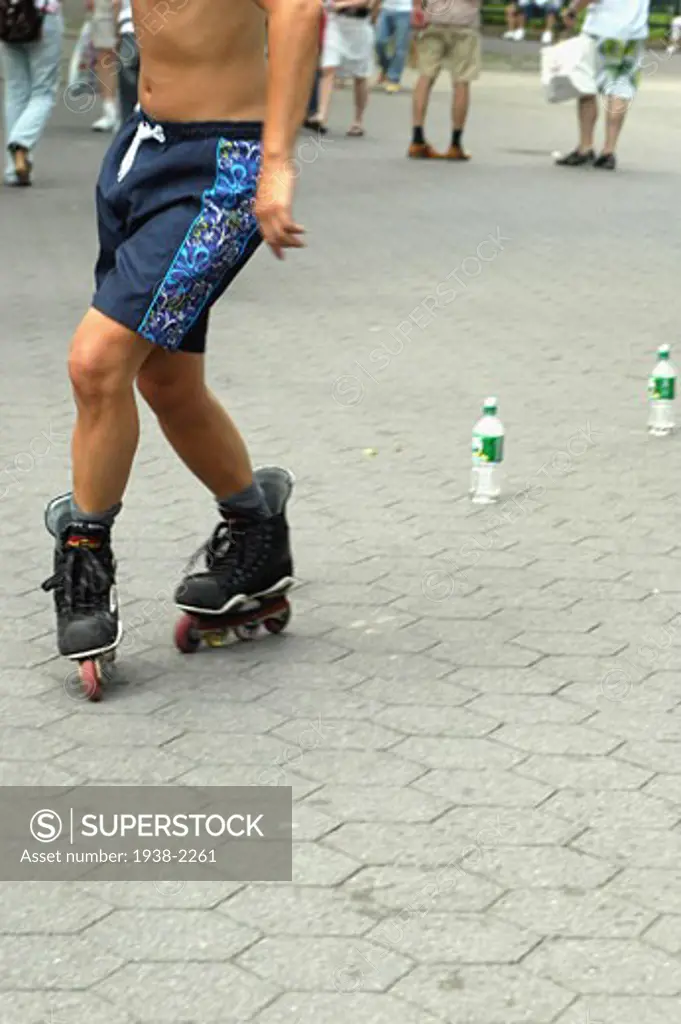 Roller skater skating backwards between bottles placed on the floor  in Central Park  Manhattan  New York City