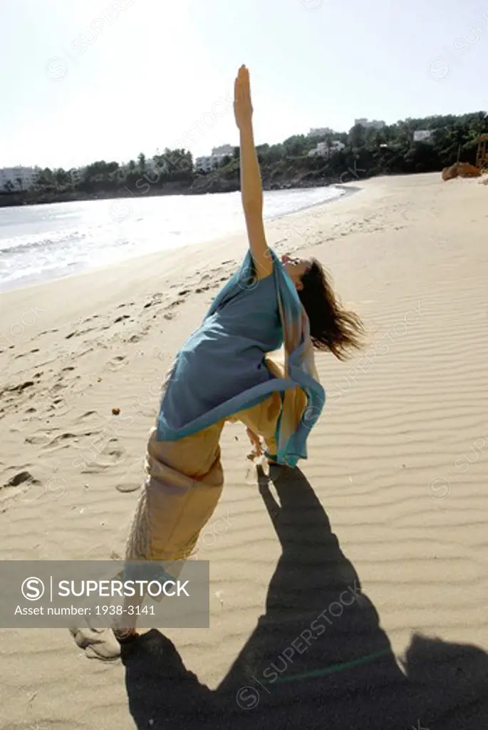 Yoga teacher and artist Lena Tancredi doing yoga on the beach, Ibiza Island, Balearic Islands, Spain
