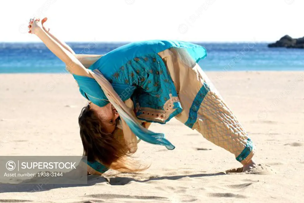 Yoga teacher and artist Lena Tancredi doing yoga on the beach, Ibiza Island, Balearic Islands, Spain