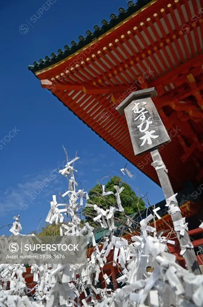 Paper with prayers wrapped around branches in front of shrine, Heian Jingu Shrine, Kyoto Prefecture, Honshu, Japan