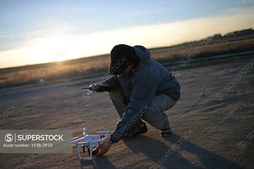 Young man flying Phantom Drone outdoors at sunset
