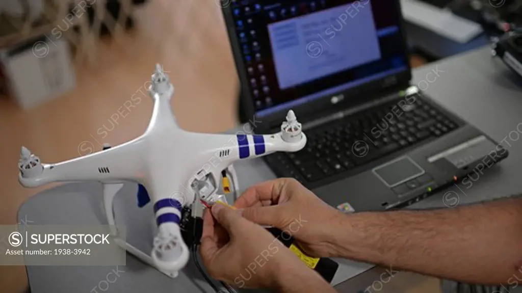 Young man calibrating GPS of Phantom Drone with laptop computer