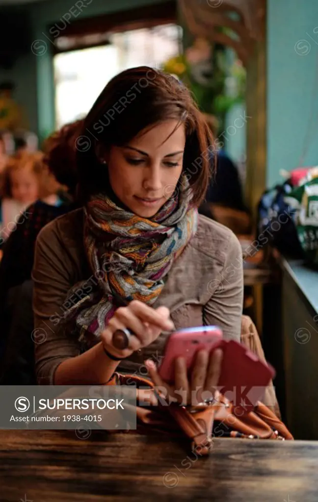 Attractive young woman using mobile phone in cafe