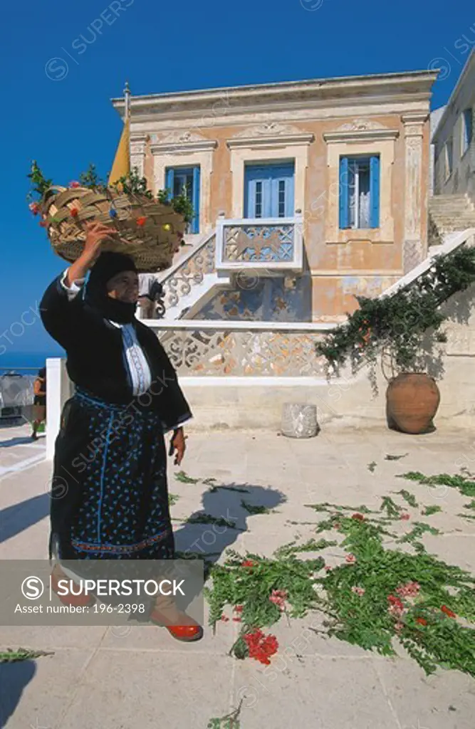 Greece, Dodecanese, Karpathos, Woman carrying basket on head