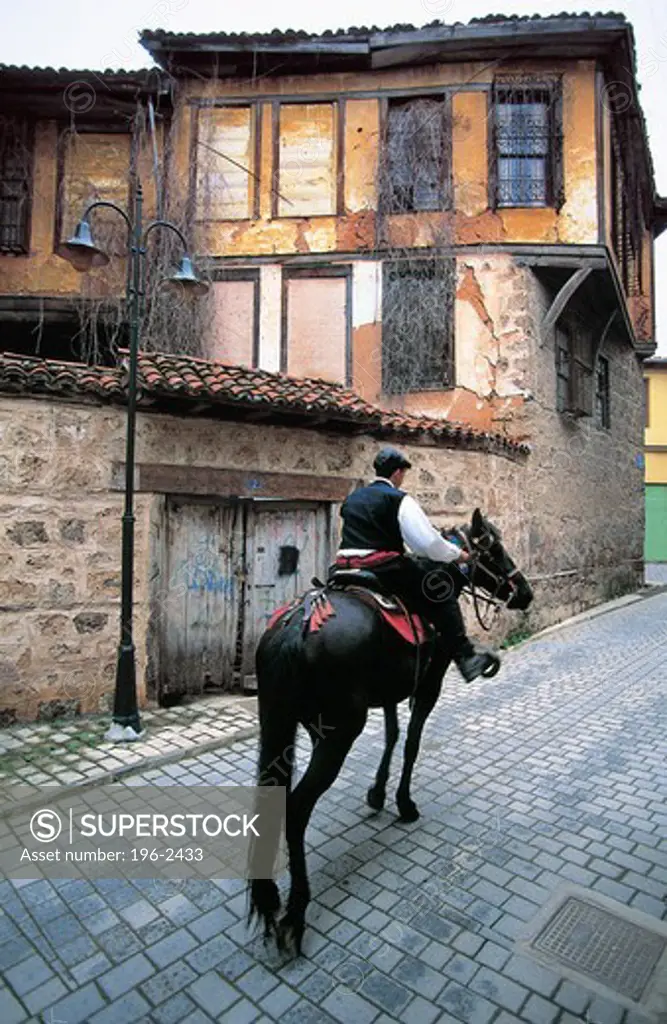 Greece, Macedonia, Naoussa, Man riding donkey in village