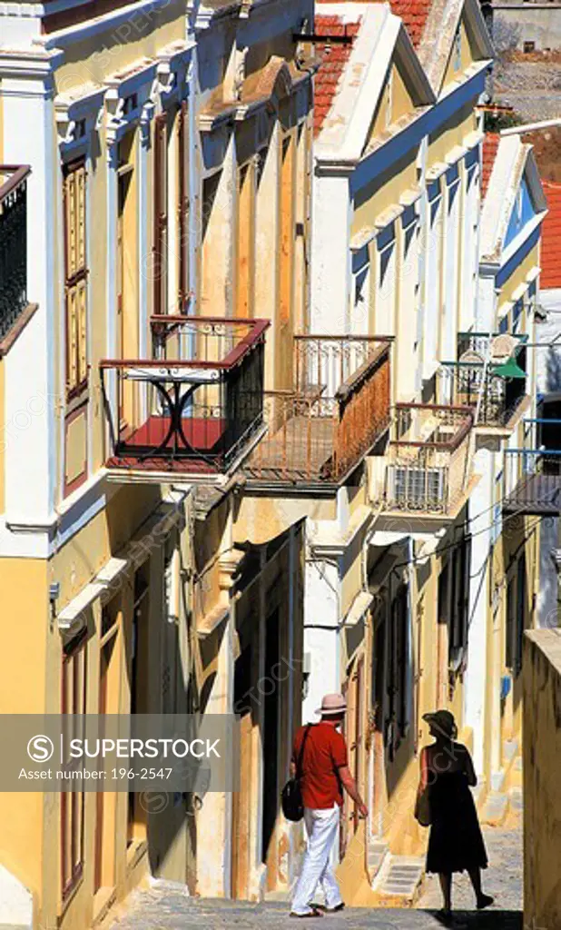Greece, Dodecanese, Simi, Tourists walking down narrow street