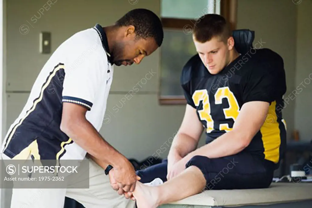 Doctor examining a football player's leg