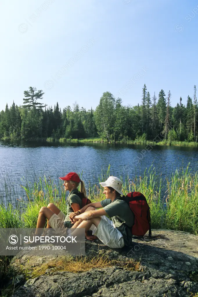Teenage hikers at Lyons Lake, Whiteshell Provincial Park, Manitoba, Canada.