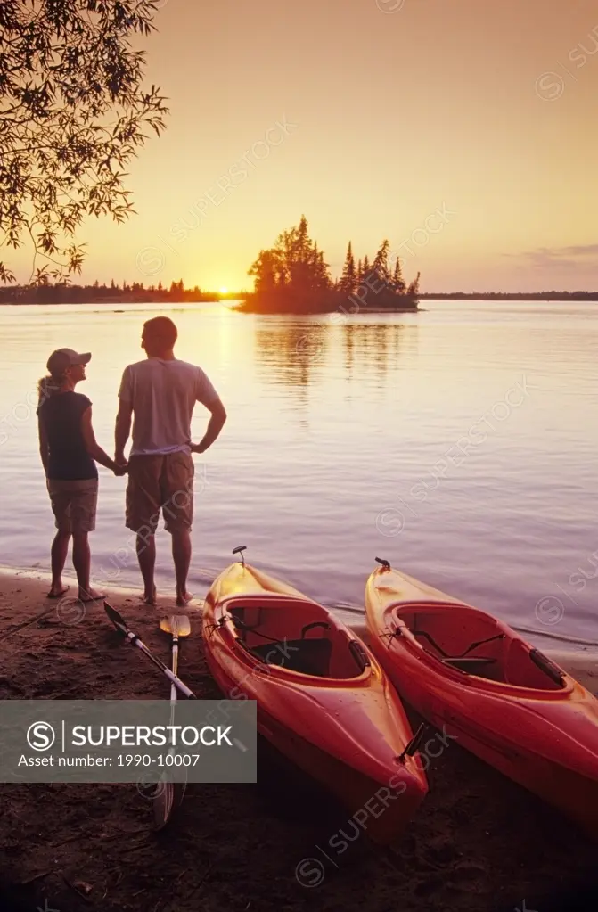 Couple with kayaks at Otter Falls campground, Whiteshell Provincial Park, Manitoba, Canada.