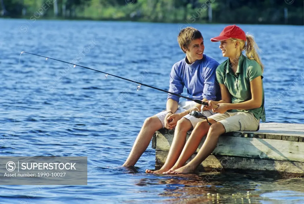 Teenagers on dock, Lyons Lake, Whiteshell Provincial Park, Manitoba, Canada.