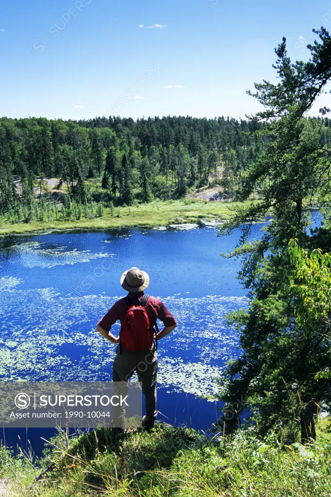 Hiker overlooking the Lilly Pond, Whiteshell Provincial Park, Manitoba, Canada.