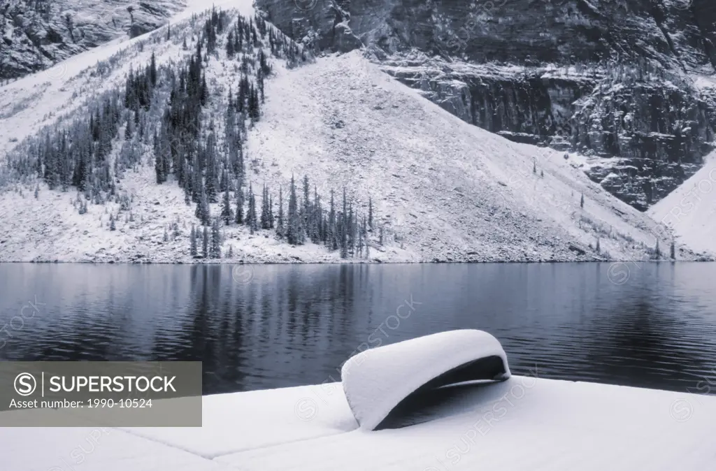 Canoe on dock at Moraine Lake after first snowfall, Banff National Park, Alberta, Canada.