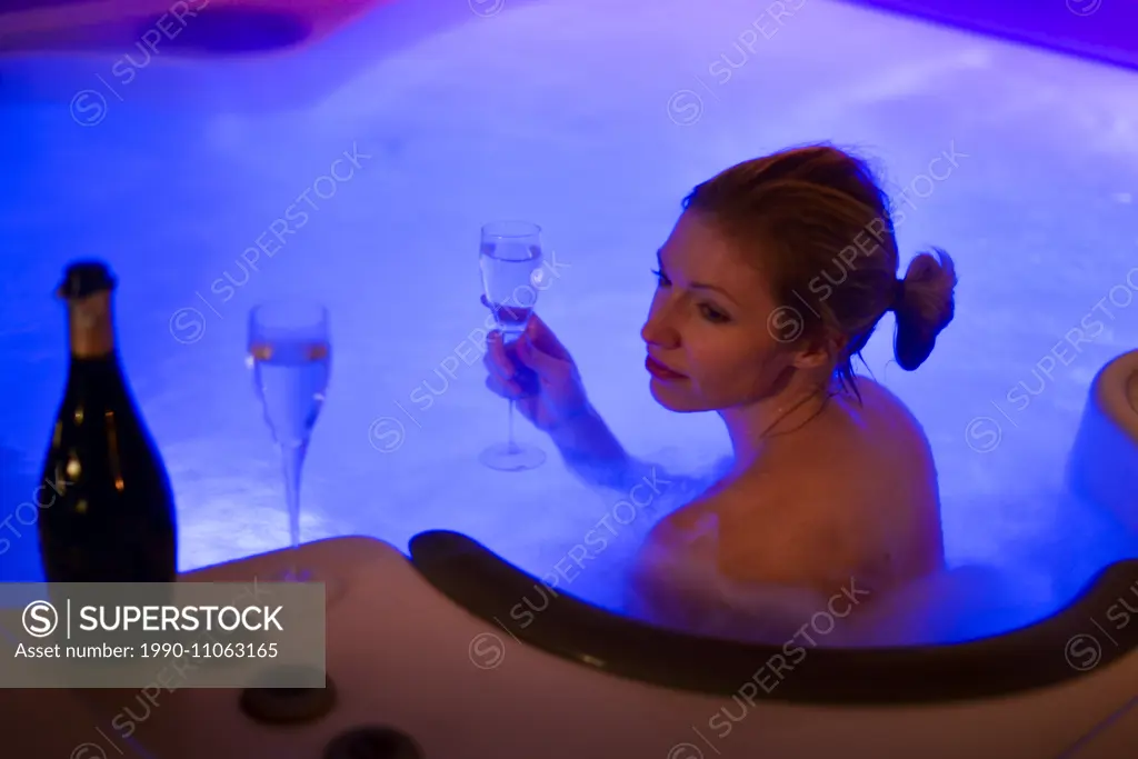 Attractive women relaxing in hot tube and drinking champagne on New Years Eve