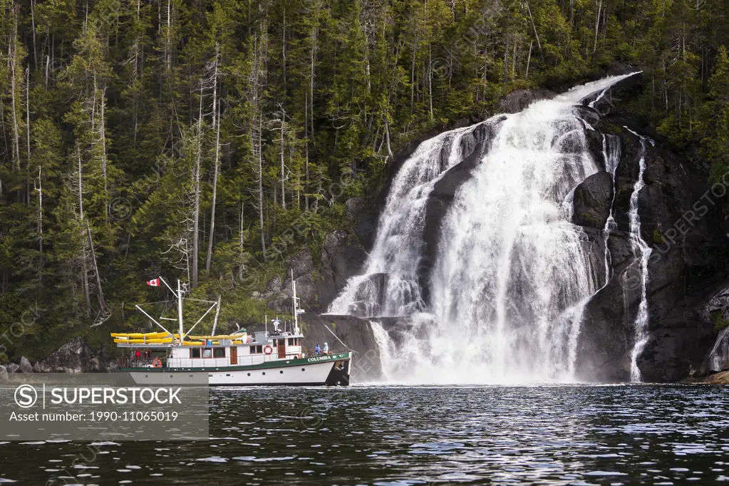 Columbia III steams alongside a cascading waterfall while traveling through Kynoch Inlet on British Columbia's Northern Coast. Fjordland, Great Bear R...