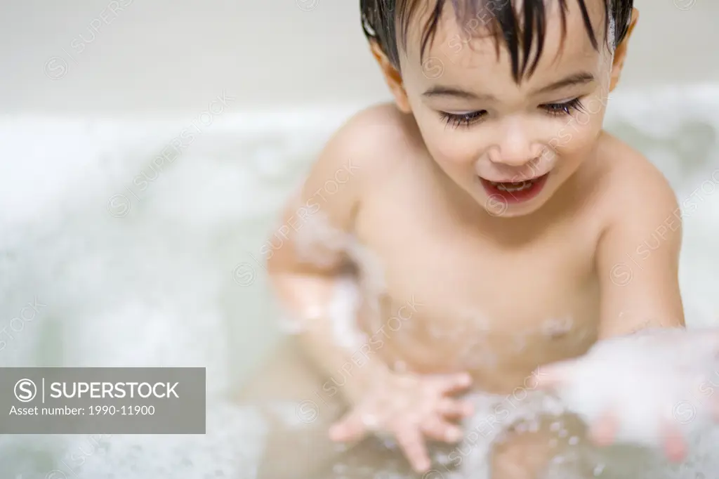 2 year old boy taking a bath, Montreal, Quebec, Canada
