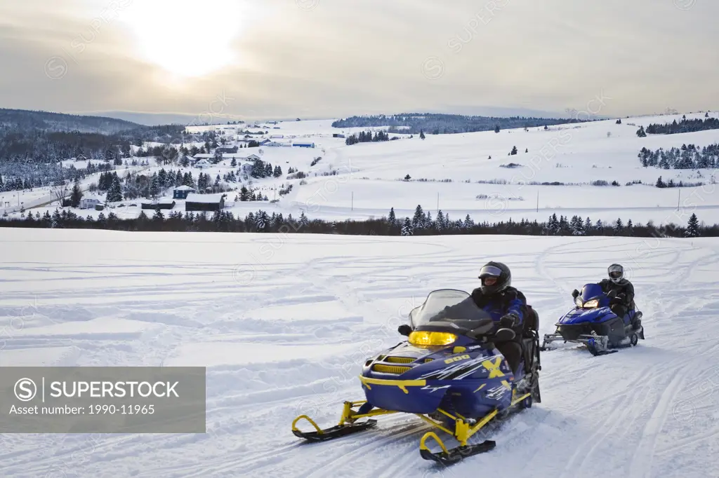 Snowmobilers travelling through Charlevoix´s back country, Rang Sainte_Marie, Les Éboulements, Québec, Canada.