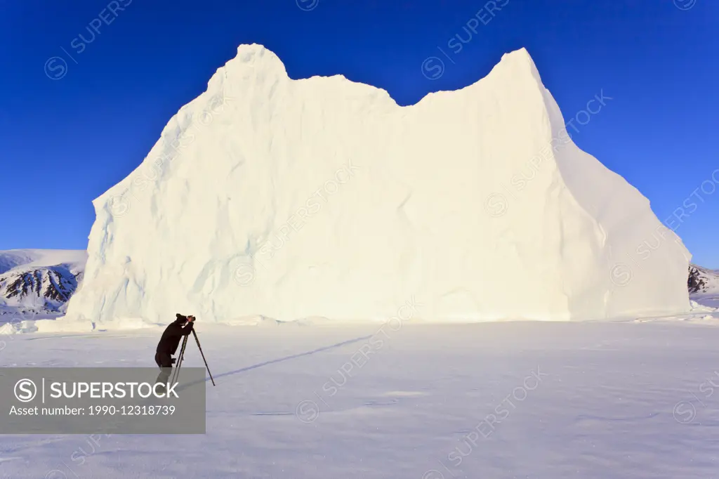 Photographer in front of an iceberg in Baffin Bay on the Arctic Ocean, north of Baffin Island, Nunavut, Canada in the Canadian Arctic