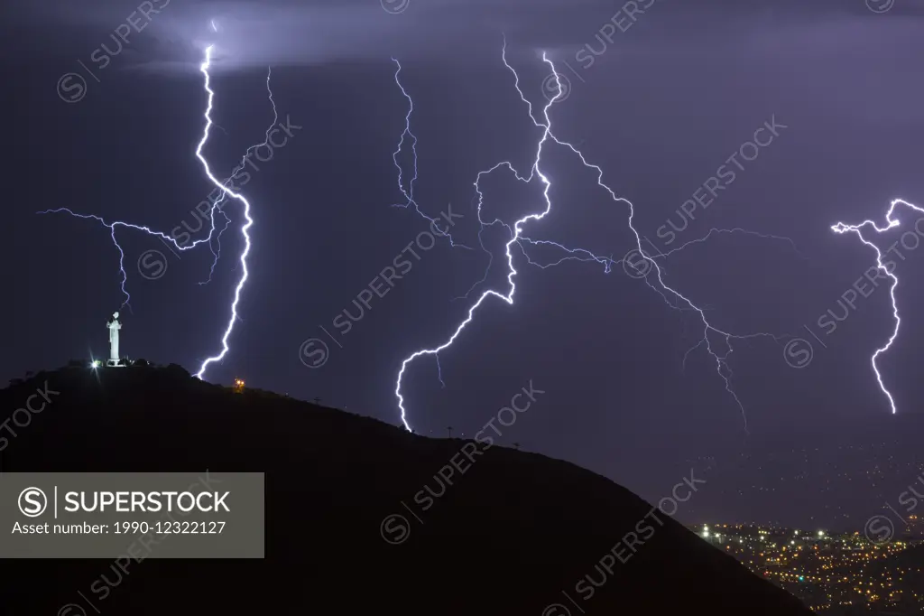 Lightning during a thunderstorm over the city of Cochabamba, Bolivia. El Cristo is in the foreground.