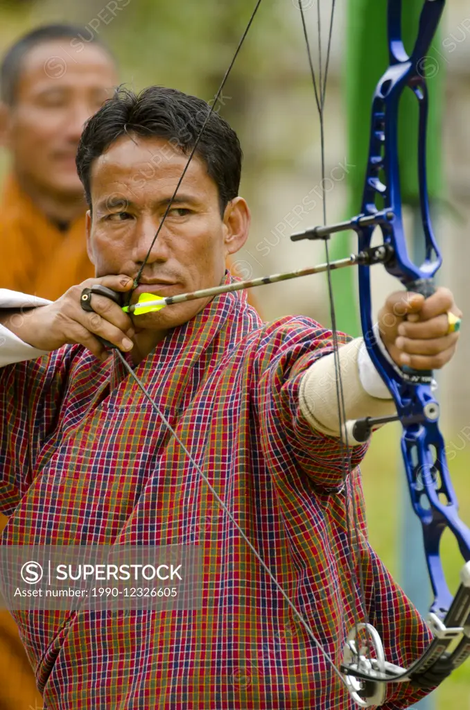 A Buddhist man takes aim with a bow and arrow in Bhutan, where the national sport is archery