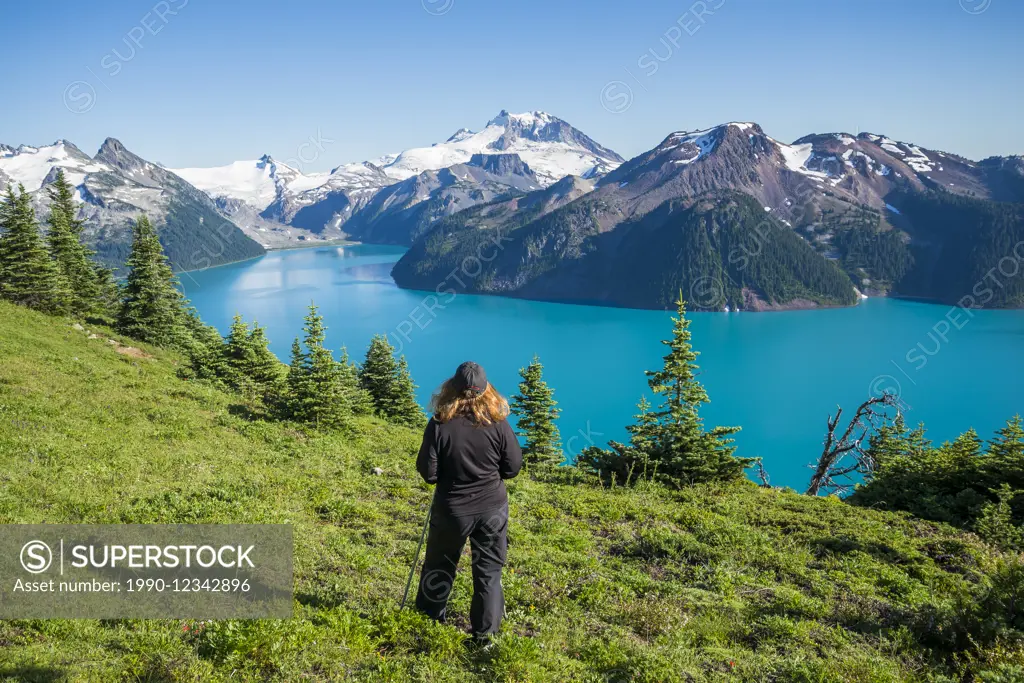 Woman hiker enjoys panoramic view of Garibaldi Lake, Garibaldi Provincial Park, British Columbia, Canada