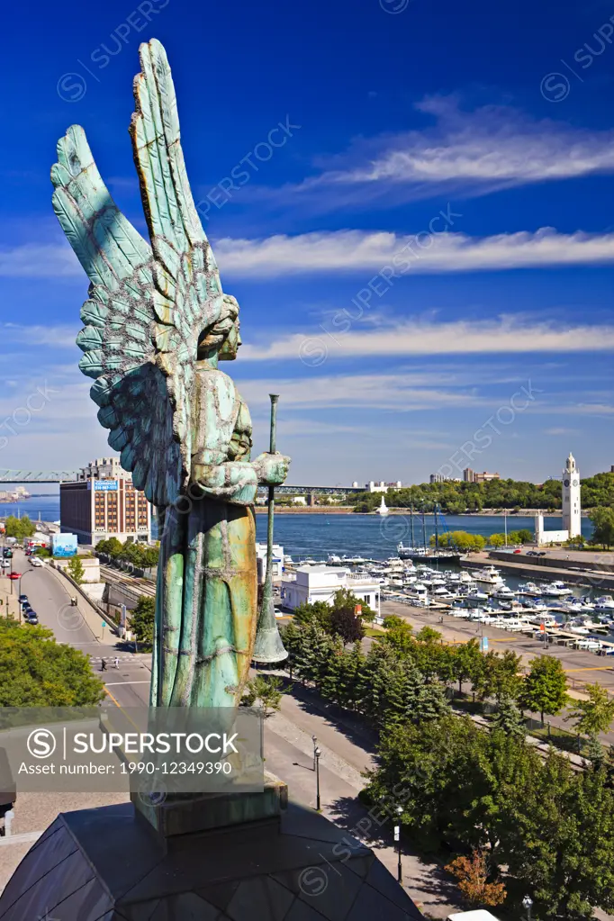 Angel atop the Notre-Dame-de-Bon-Secours Chapel overlooking the Old Port Clock Tower and Yacht Club Montreal in Old Montreal, Montreal, Quebec, Canada...