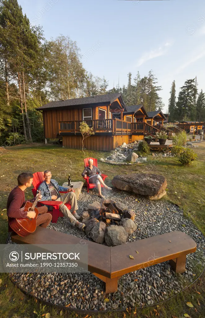 Friends gather around a fire while staying at the Ecoscape Cabins facility located in Port Hardy