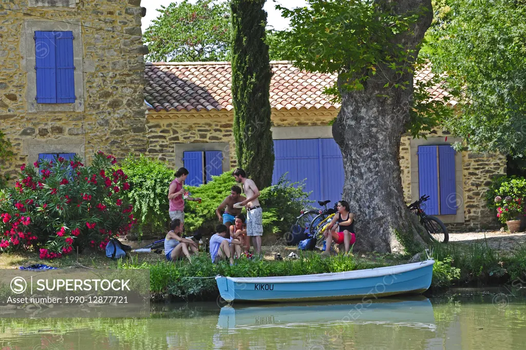 cyclists resting beside the Canal du Midi at Le Somail, Aude Department, France