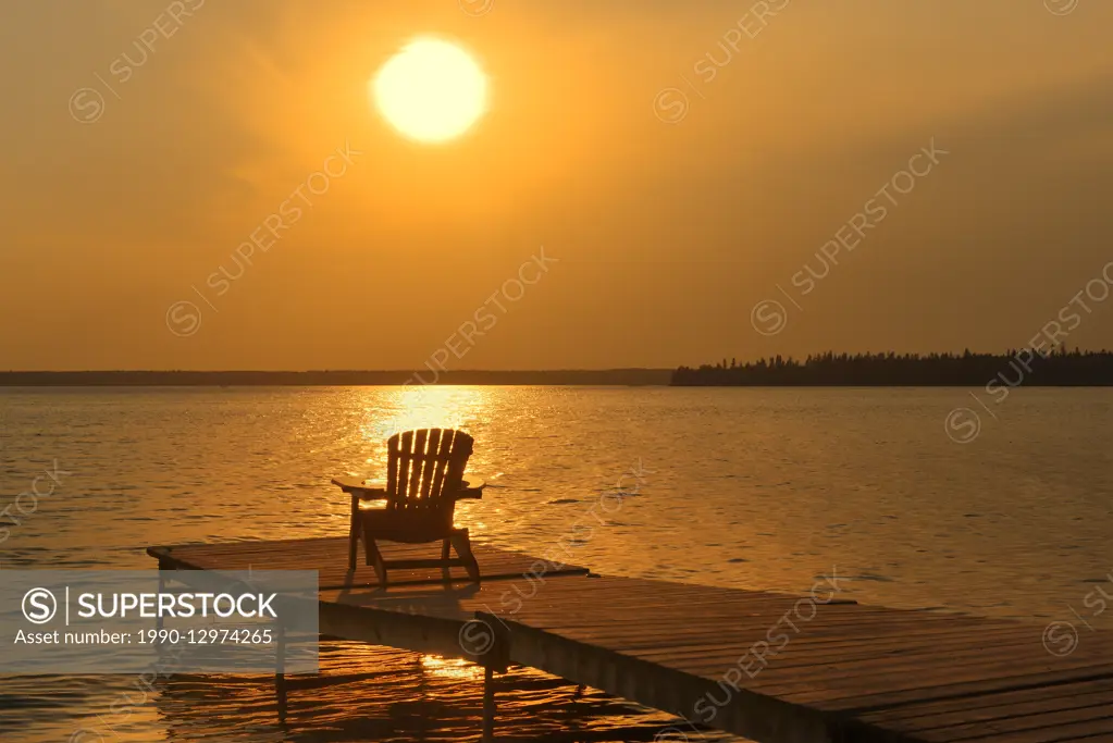 Muskoka chair on dock at Clear Lake, Riding Mountain National Park, Manitoba, Canada