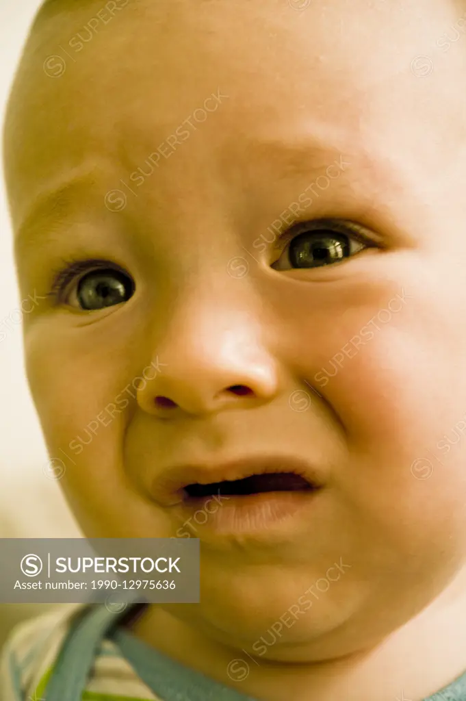 portrait of an infant boy with unhappy expression on his face