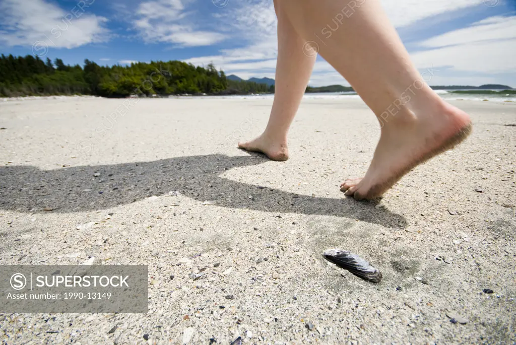 A woman walks on the beach at Vargas Island in Clayoquot Sound near Tofino, British Columbia, Canada.