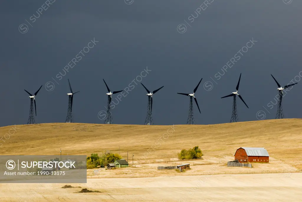 Stormy skies and windmills loom over a farm near Pincher Creek, Alberta, Canada.