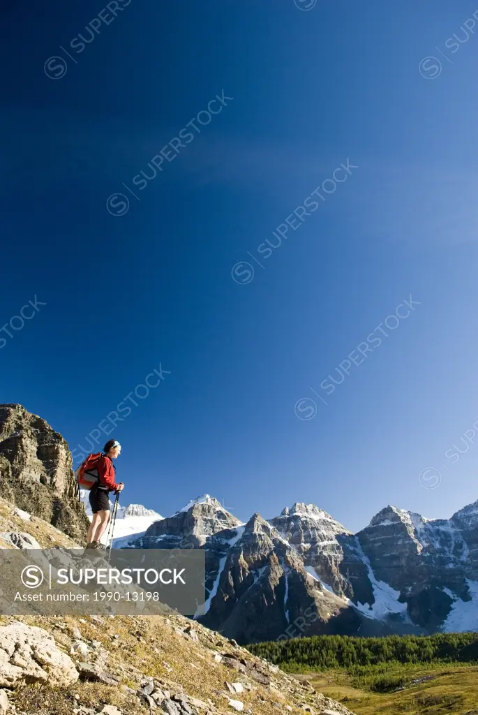 A female hiker looks out over Larch Valley on the trail to Sentinel Pass near Moraine Lake, Banff National Park, Alberta, Canada.