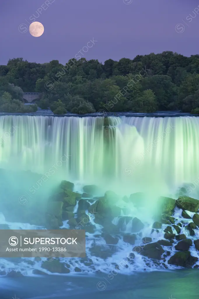 The American Falls with Full moon at dusk lit with lights photographed from Niagara Falls, Ontario, Canada