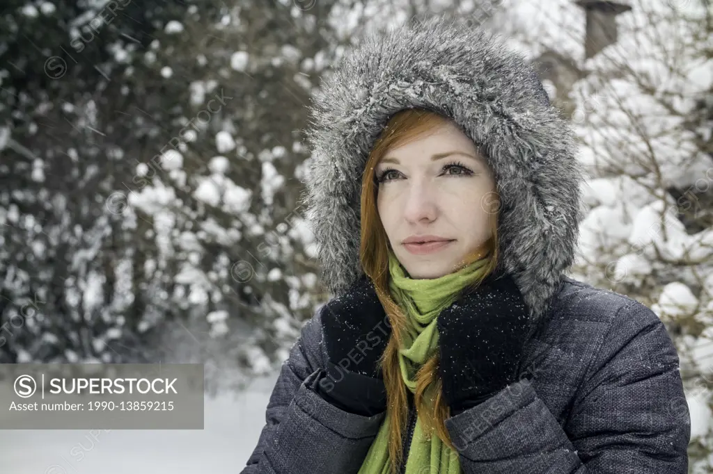 Woman (40) outdoors in winter snowfall.